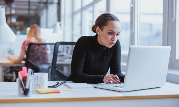 Woman sitting with laptop at work