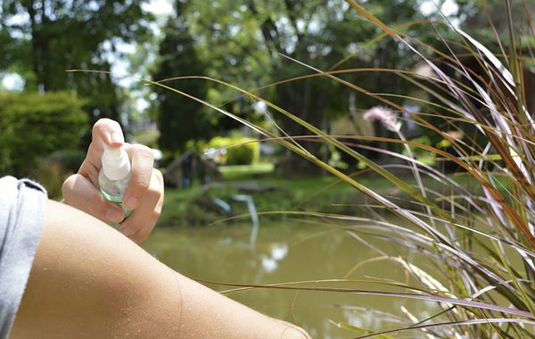 Woman spraying mosquito repellent